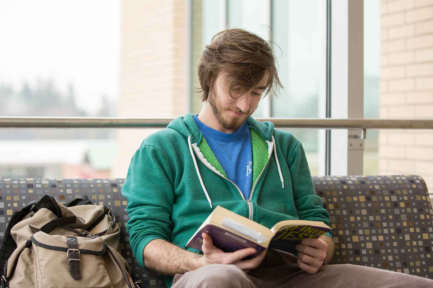 Student reading a book sitting down